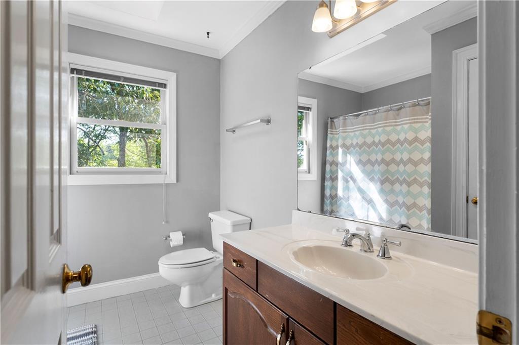 24 Commerce Row Northeast Cartersville, GA 30121 - Photo 26 of 37 a bathroom with a granite countertop sink toilet a large mirror and a window