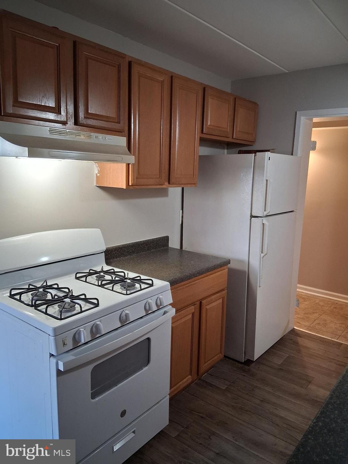 2305 Freetown Court, Unit 2B Reston, VA 20191 - Photo 2 of 15 a kitchen with granite countertop wooden cabinets and a stove top oven