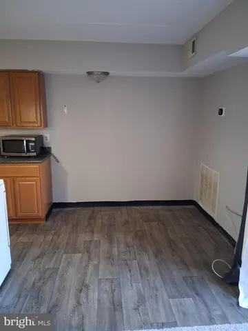 a view of a kitchen with wooden floor and a sink