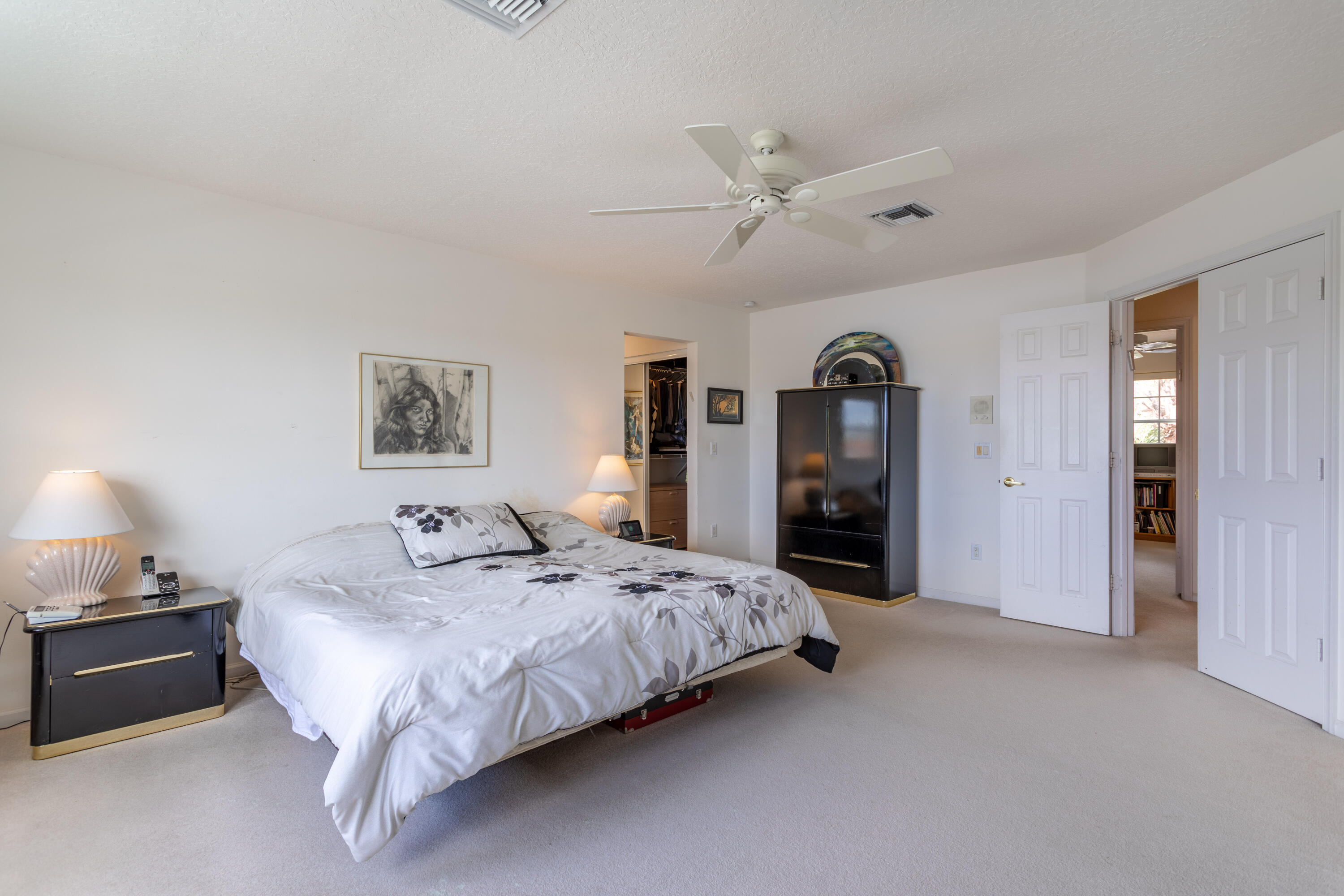 12601 Maypan Drive Boca Raton, FL 33428 - Photo 22 of 46 a spacious bedroom with a bed a lamp and a chandelier