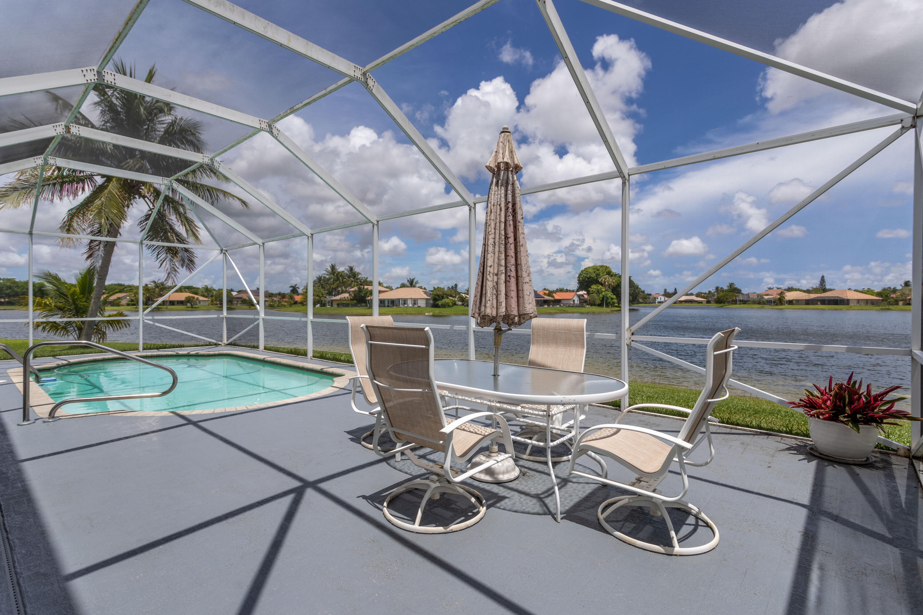 12601 Maypan Drive Boca Raton, FL 33428 - Photo 31 of 46 a view of a patio with a dining table and chairs with wooden floor