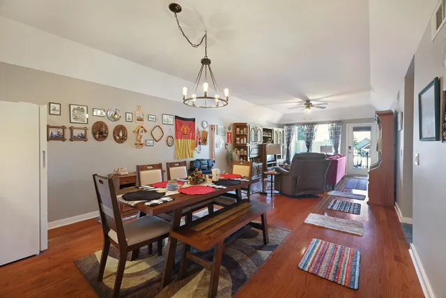 a view of a dining room with furniture a rug and wooden floor