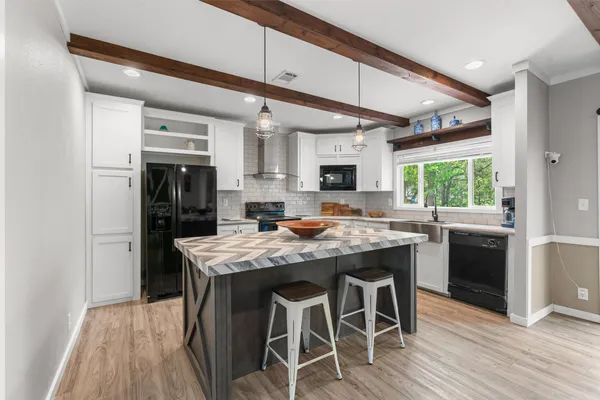 a kitchen with stainless steel appliances granite countertop a kitchen island a stove a table and chairs in it