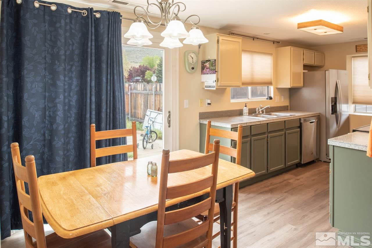 17165 Touraco Street Reno, NV 89508 - Photo 5 of 24 a kitchen with stainless steel appliances granite countertop a stove a sink dishwasher and cabinets with wooden floor