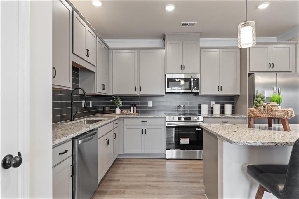 310 Caroline Place, Unit 100 Villa Rica, GA 30180 - Photo 13 of 30 a kitchen with stainless steel appliances granite countertop a sink stove and refrigerator
