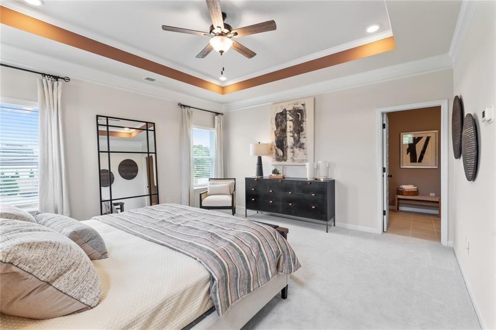310 Caroline Place, Unit 100 Villa Rica, GA 30180 - Photo 28 of 30 a spacious bedroom with a bed and a chandelier