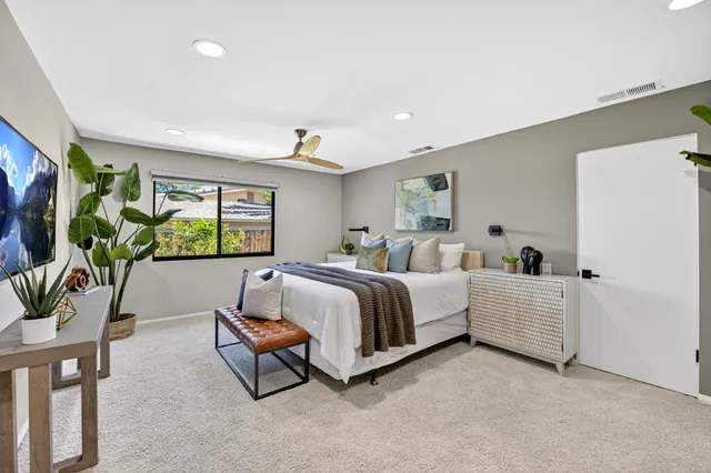 a bedroom with a large bed and a chandelier