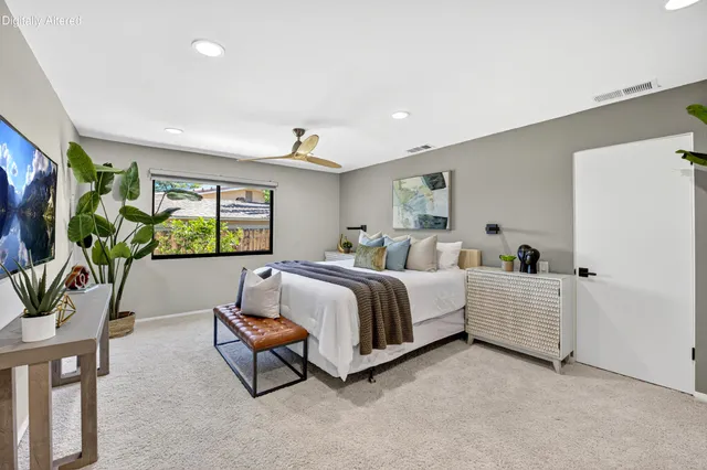 a bedroom with a large bed and a chandelier