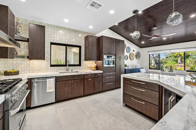 a kitchen with stainless steel appliances granite countertop a stove and cabinets