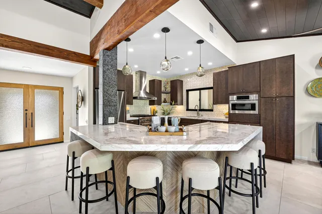 a kitchen with stainless steel appliances kitchen island granite countertop a dining table and chairs