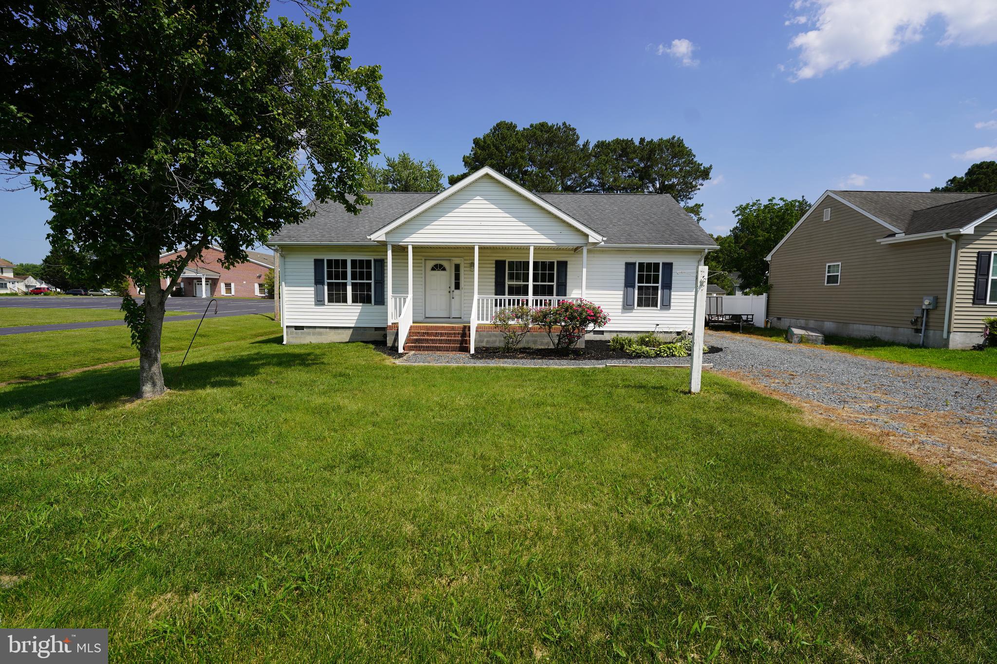 a front view of a house with a garden and trees