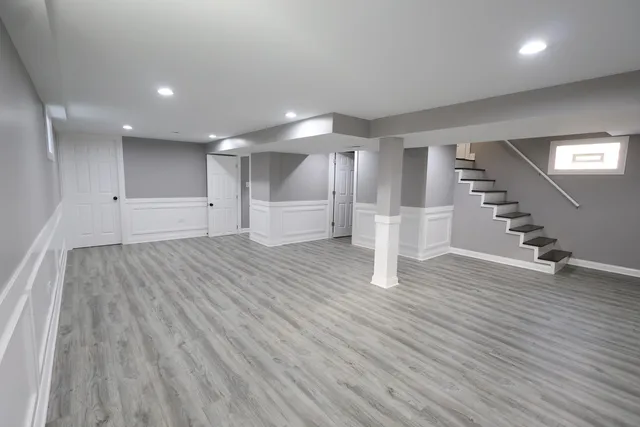 a view of empty room with wooden floor and stairs