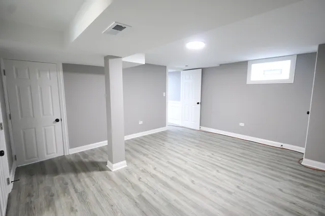 a view of an empty room with wooden floor and closet