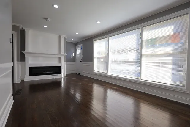 a view of empty room with wooden floor and fireplace