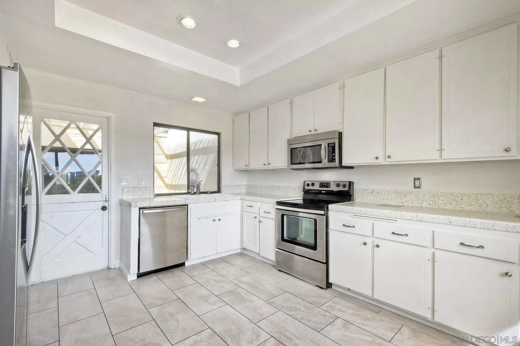 13416 The Square Poway, CA 92064 - Photo 10 of 22 a kitchen with white cabinets appliances and a window