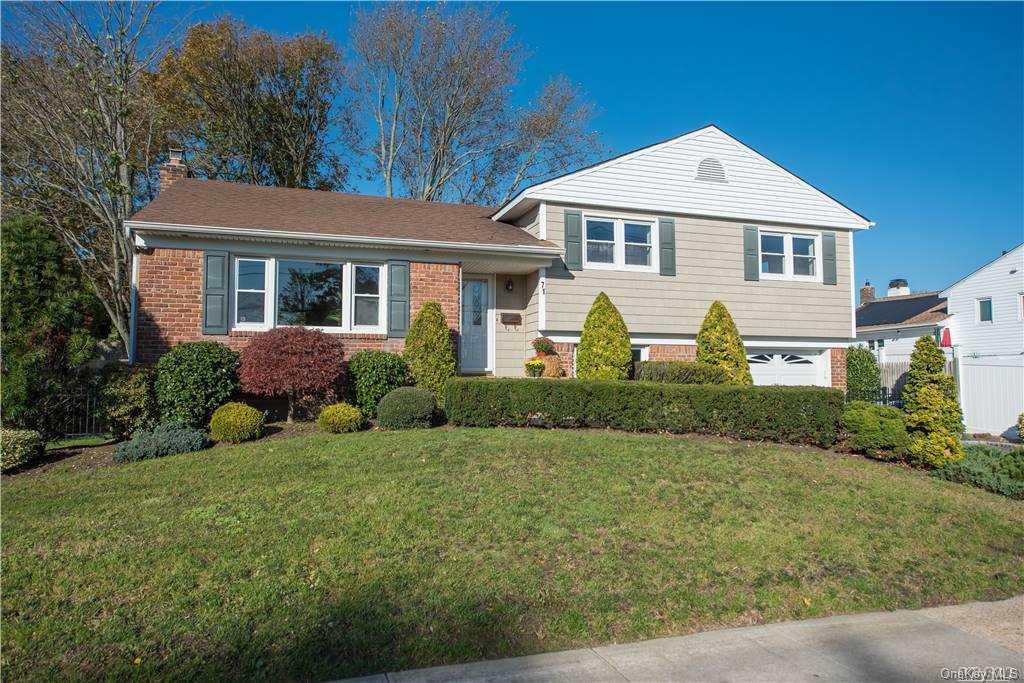 a front view of a house with a yard and potted plants