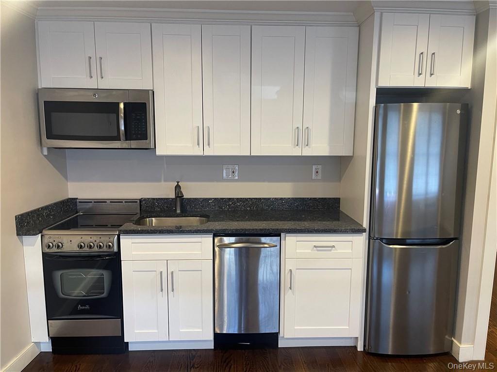 17 Cedar Street, Unit 1 Dobbs Ferry, NY 10522 - Photo 4 of 9 Kitchen featuring stainless steel appliances, white cabinets, dark stone counters, and dark wood-type flooring