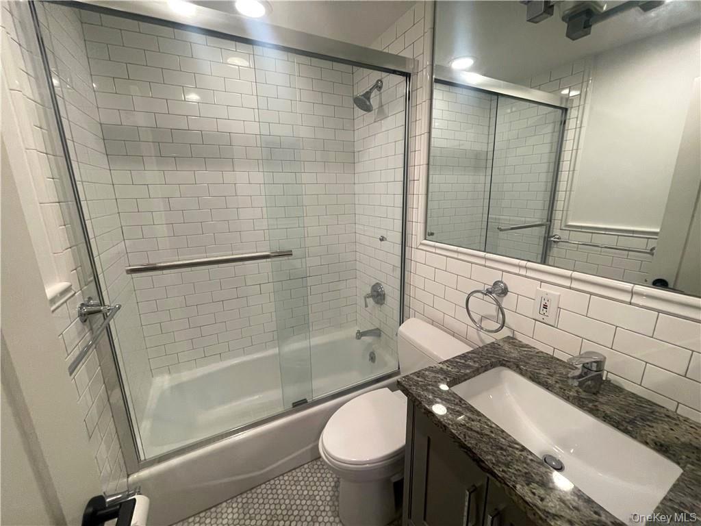 17 Cedar Street, Unit 1 Dobbs Ferry, NY 10522 - Photo 7 of 9 Full bath featuring enclosed tub / shower combo, vanity, tile walls, and decorative backsplash