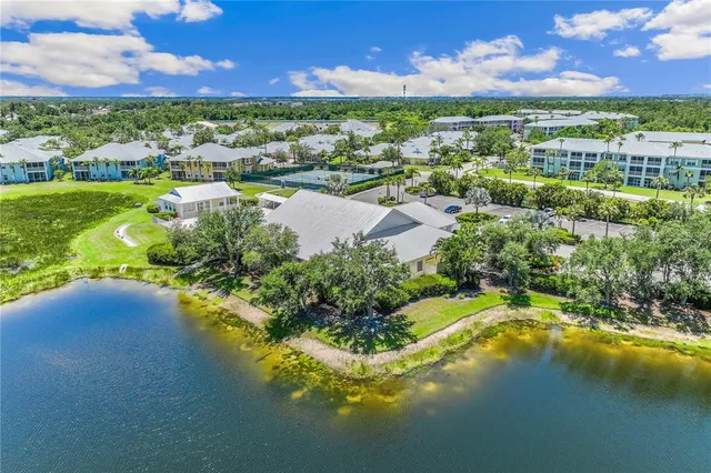 an aerial view of residential houses with outdoor space and lake view