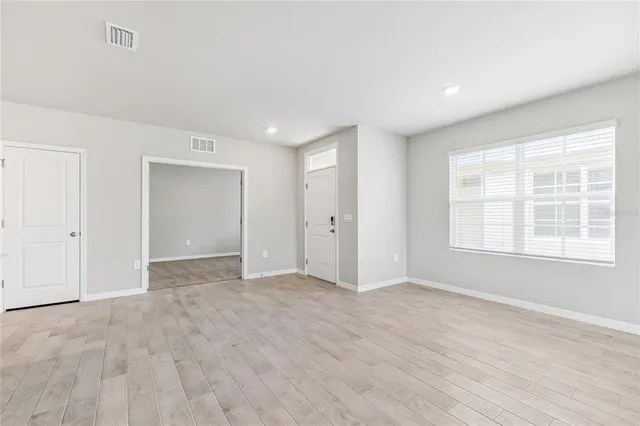 wooden floor in an empty room with a window