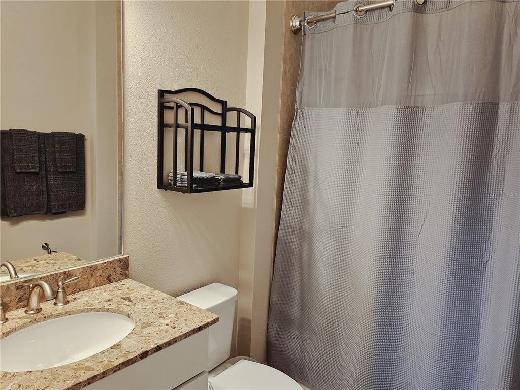 10468 Crooked Creek Drive Venice, FL 34293 - Photo 36 of 44 a bathroom with a granite countertop sink toilet and mirror