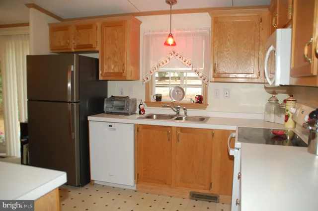 a kitchen with granite countertop a refrigerator and a sink