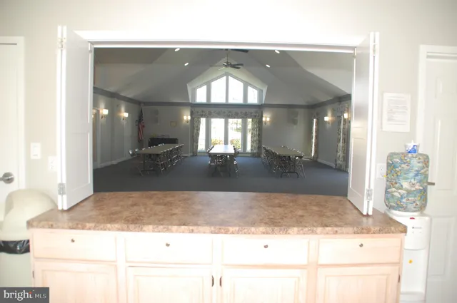 a room with wooden floor pool table and windows