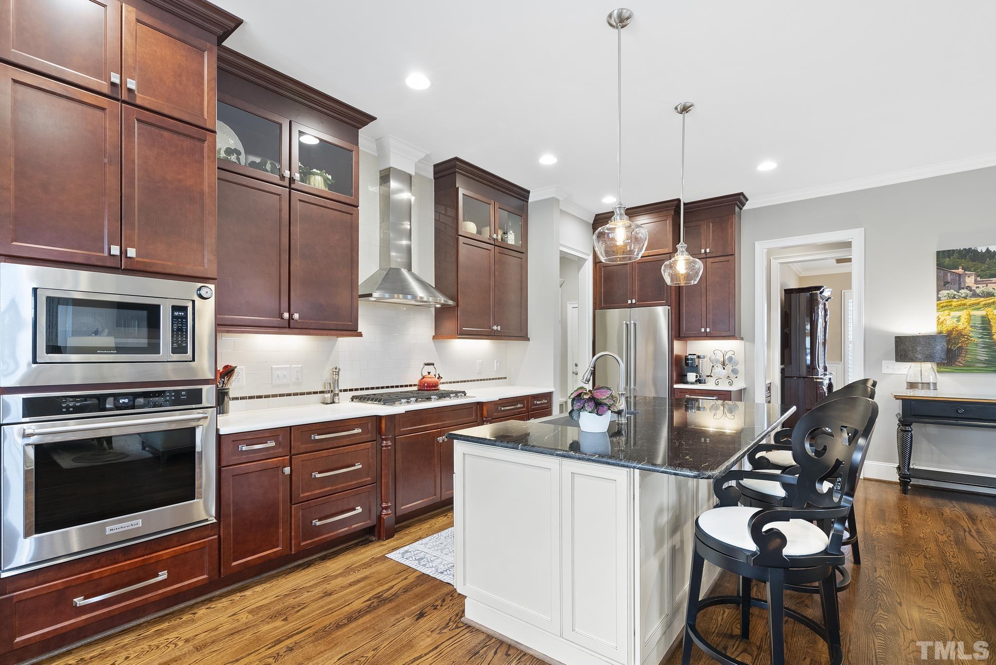 2524 Highgate Oak Drive Cary, NC 27519 - Photo 23 of 70 a kitchen with stainless steel appliances granite countertop a stove top oven a sink dishwasher a dining table and chairs with wooden floor