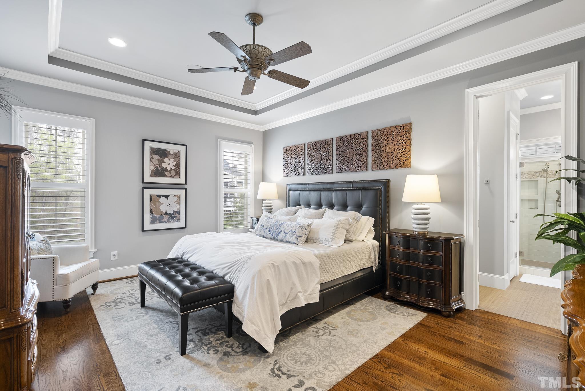 2524 Highgate Oak Drive Cary, NC 27519 - Photo 30 of 70 a bedroom with a large bed a chandelier and windows