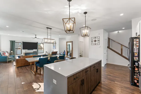a view of a dining room and livingroom with furniture wooden floor a chandelier