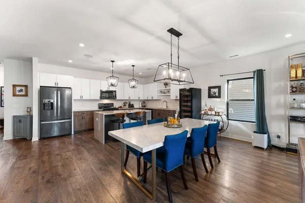 a view of kitchen with refrigerator a dining table and chairs