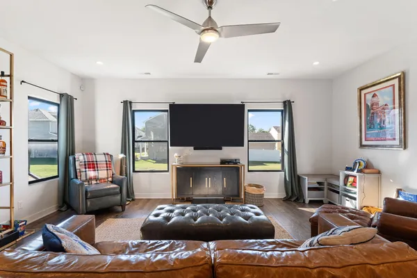 a living room with furniture a flat screen tv and a floor to ceiling window