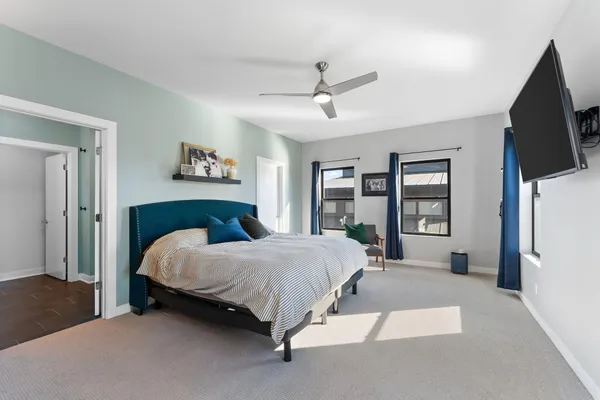 a bedroom with a bed flat screen tv and a large window