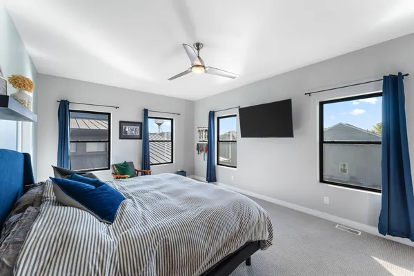 a bedroom with a bed window and a flat screen tv