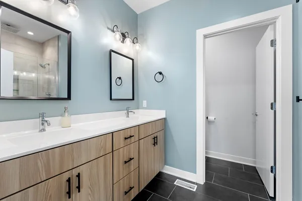 a bathroom with a double vanity sink and mirror