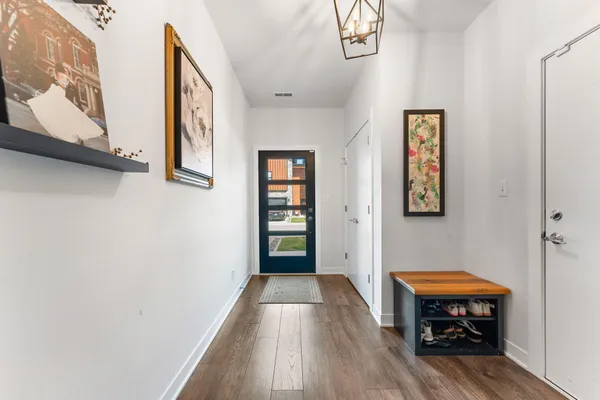a view of a hallway with wooden floor and a bedroom