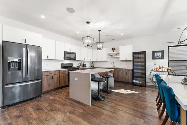 a kitchen with granite countertop a refrigerator oven a sink dishwasher and a stove with wooden floor