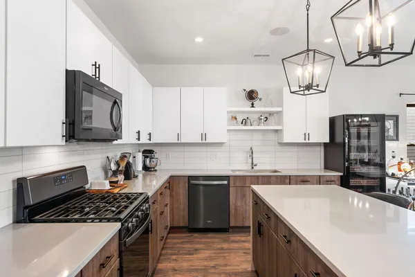 a kitchen with stainless steel appliances a sink stove and cabinets