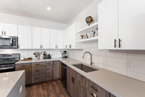 a kitchen with stainless steel appliances a sink stove and cabinets