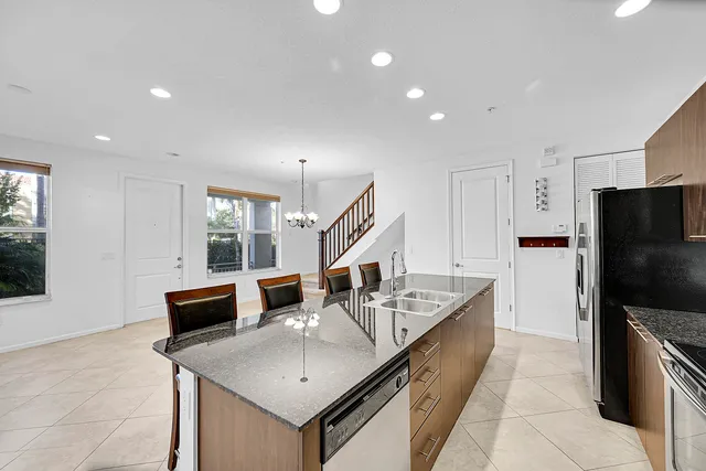 a kitchen with stainless steel appliances granite countertop a sink and a refrigerator