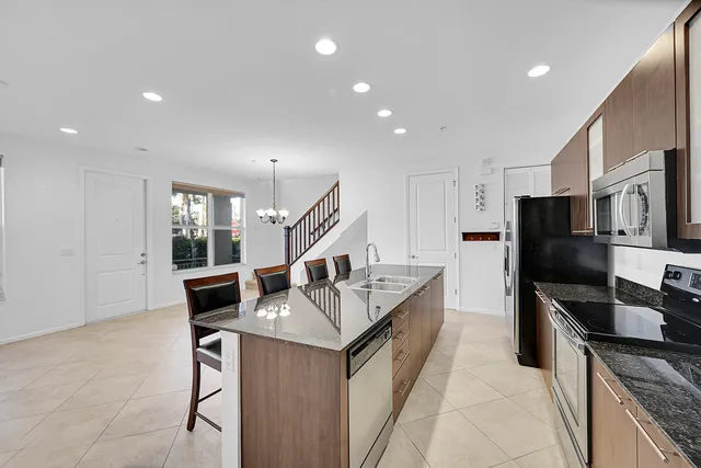 a kitchen with stainless steel appliances granite countertop a sink and a refrigerator