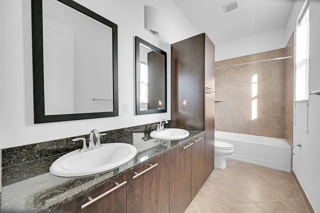 a bathroom with a double vanity sink double mirror and a bathtub