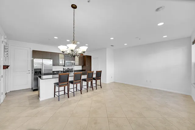 a view of a dining room and a chandelier fan a kitchen view and a window