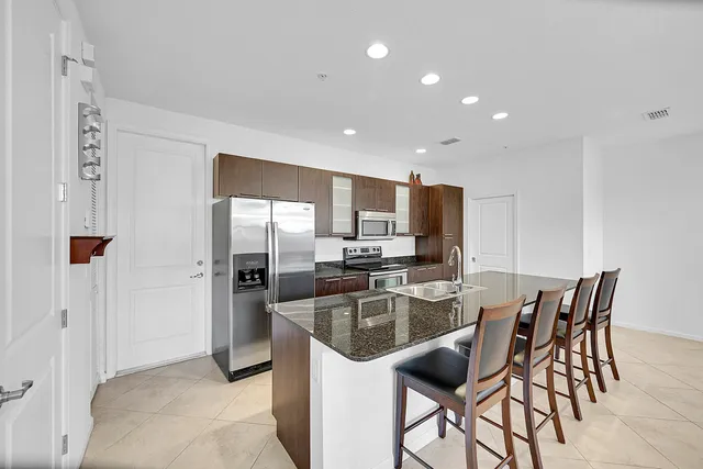 a kitchen with stainless steel appliances kitchen island granite countertop a sink and cabinets