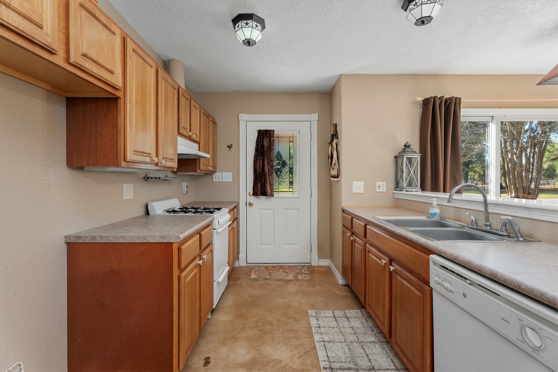 10205 Fostoria Road Cleveland, TX 77328 - Photo 30 of 44 a kitchen with granite countertop a sink stove and cabinets