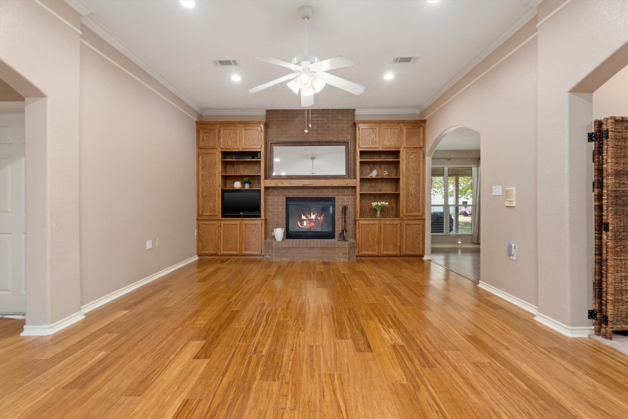 10205 Fostoria Road Cleveland, TX 77328 - Photo 8 of 44 an empty room with wooden floor fireplace and windows
