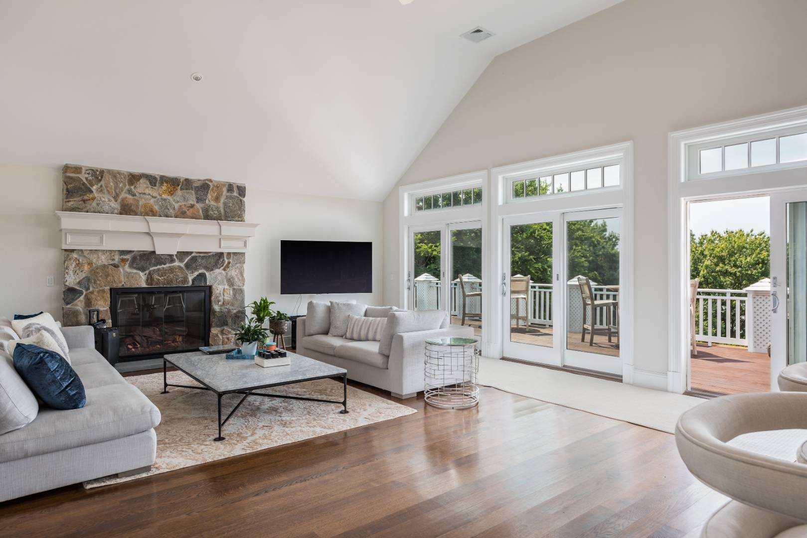 19 Kellis Way Bridgehampton, NY 11932 - Photo 10 of 26 a living room with furniture large windows and a fireplace