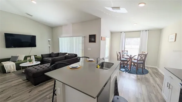 a living room with furniture a flat screen tv and a large window
