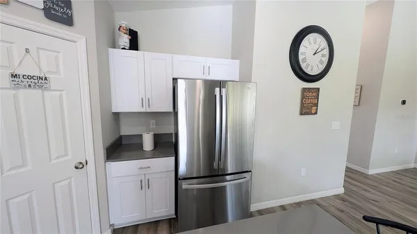 a kitchen with stainless steel appliances granite countertop a refrigerator a stove and a sink with wooden floor