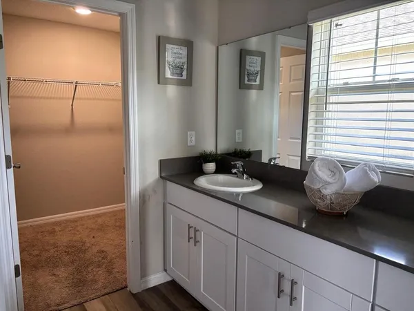 a kitchen with granite countertop white cabinets and stainless steel appliances